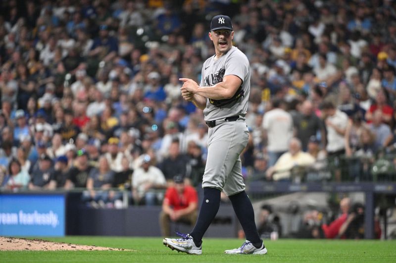 Apr 27, 2024; Milwaukee, Wisconsin, USA; New York Yankees pitcher Carlos Rodón (55) looks over to the dug out as he rubs down the ball and walks back to the mound against the Milwaukee Brewers in the fifth inning at American Family Field. Mandatory Credit: Michael McLoone-USA TODAY Sports