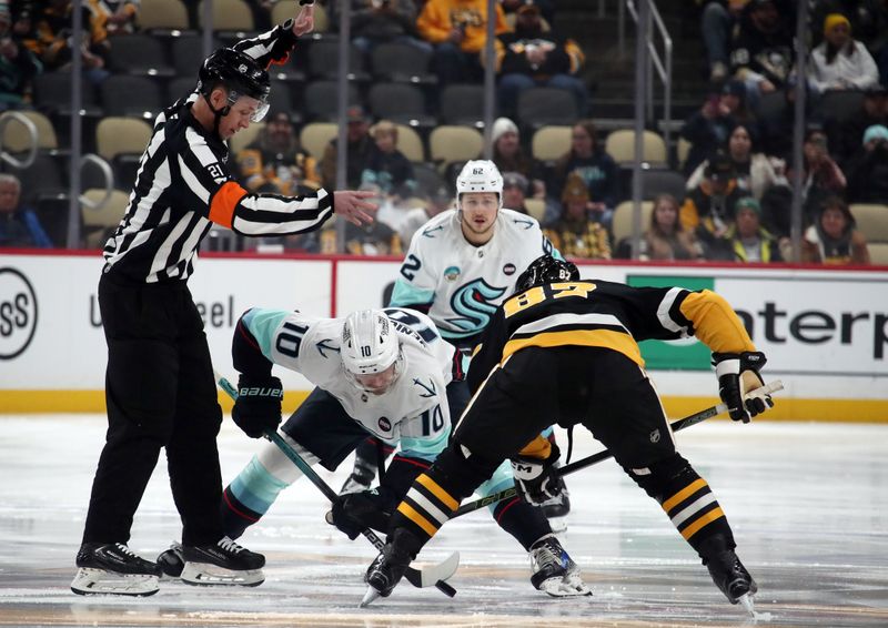 Jan 14, 2025; Pittsburgh, Pennsylvania, USA;  Seattle Kraken center Matty Beniers (10) and Pittsburgh Penguins center Sidney Crosby (87) take the opening face-off at PPG Paints Arena. Mandatory Credit: Charles LeClaire-Imagn Images