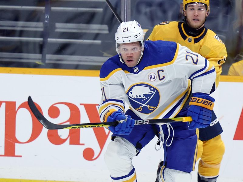 Mar 7, 2024; Nashville, Tennessee, USA; Buffalo Sabres right wing Kyle Okposo (21) looks to control the puck with Nashville Predators center Mark Jankowski (17) at Bridgestone Arena. Mandatory Credit: Alan Poizner-USA TODAY Sports