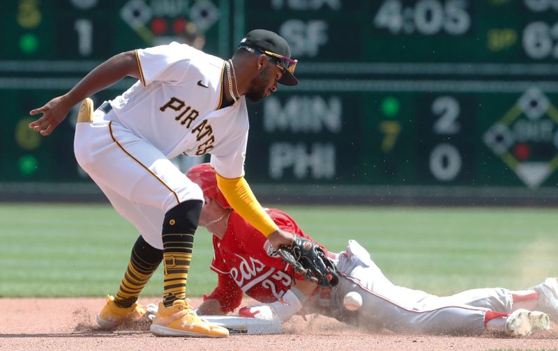 Aug 13, 2023; Pittsburgh, Pennsylvania, USA; Cincinnati Reds center fielder TJ Friedl (29) steals second base as Pittsburgh Pirates shortstop Liover Peguero (60) drops the throw during the seventh inning at PNC Park. Mandatory Credit: Charles LeClaire-USA TODAY Sports