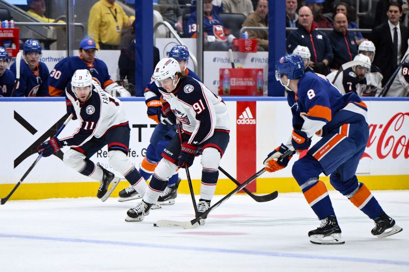 Dec 7, 2023; Elmont, New York, USA; Columbus Blue Jackets center Kent Johnson (91) controls the puck as New York Islanders defenseman Noah Dobson (8) defends during the first period at UBS Arena. Mandatory Credit: John Jones-USA TODAY Sports