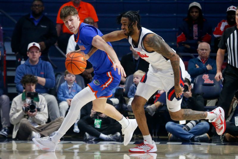 Feb 21, 2026; Oxford, Mississippi, USA; Florida Gators forward/center Alex Condon (21) and Mississippi Rebels forward James Scott (4) battle for a loose ball during the first half at The Sandy and John Black Pavilion at Ole Miss. Mandatory Credit: Petre Thomas-Imagn Images