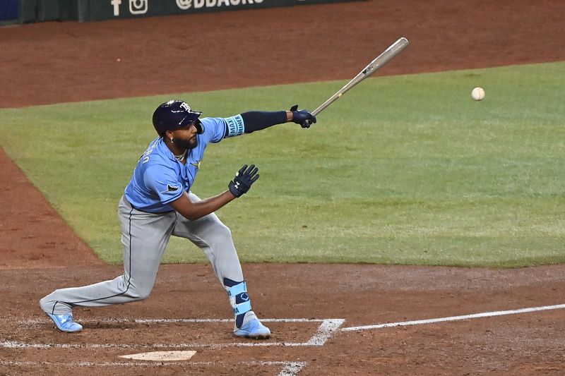 Apr 24, 2025; Phoenix, Arizona, USA;  Tampa Bay Rays third base Junior Caminero (13) hits an RBI single in the sixth inning against the Arizona Diamondbacks at Chase Field. Mandatory Credit: Matt Kartozian-Imagn Images