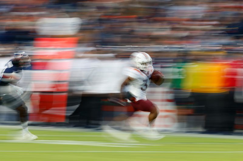 Nov 25, 2023; Charlottesville, Virginia, USA; Virginia Tech Hokies running back Bhayshul Tuten (33) carries the ball en route to a touchdown as Virginia Cavaliers cornerback Dave Herard (4) chases during the second quarter at Scott Stadium. Mandatory Credit: Geoff Burke-USA TODAY Sports