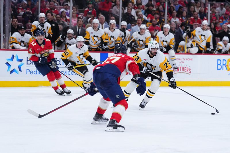 Jan 3, 2025; Sunrise, Florida, USA; Pittsburgh Penguins defenseman P.O Joseph (73) skates the puck against Florida Panthers center Evan Rodrigues (17) during the second period at Amerant Bank Arena. Mandatory Credit: Rich Storry-Imagn Images