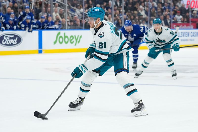 Dec 11, 2025; Toronto, Ontario, CAN; San Jose Sharks forward Alex Wennberg (21) carries the puck against the Toronto Maple Leafs during overtime at Scotiabank Arena. Mandatory Credit: John E. Sokolowski-Imagn Images