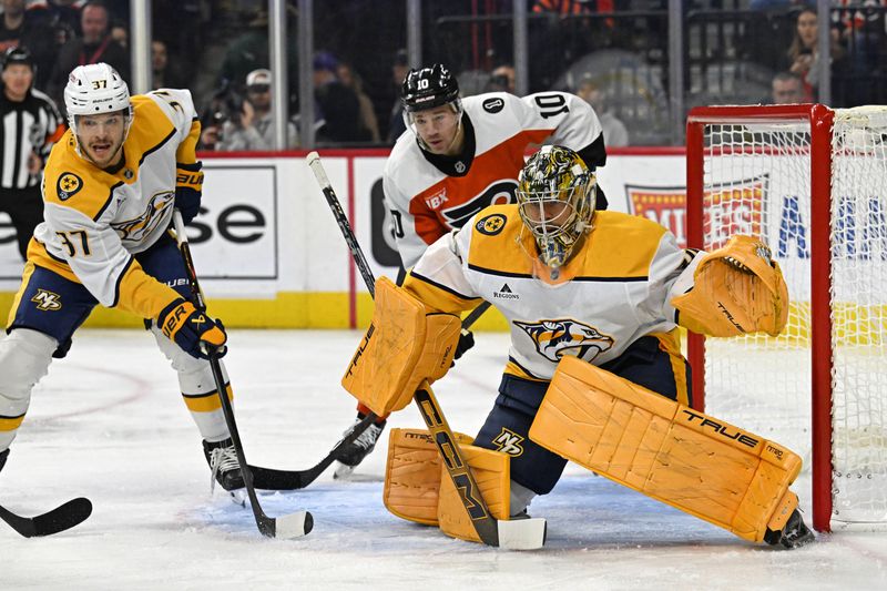 Oct 30, 2025; Philadelphia, Pennsylvania, USA; Nashville Predators goaltender Juuse Saros (74) and defenseman Nick Blankenburg (37) defend against Philadelphia Flyers right wing Bobby Brink (10) during the first period at Xfinity Mobile Arena. Mandatory Credit: Eric Hartline-Imagn Images