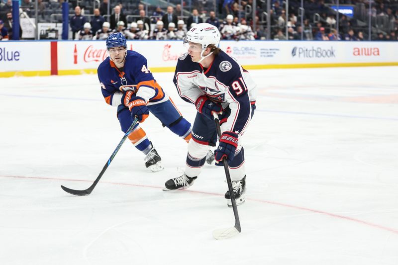 Jan 20, 2025; Elmont, New York, USA;  Columbus Blue Jackets center Kent Johnson (91) skates past New York Islanders center Jean-Gabriel Pageau (44) in the first period at UBS Arena. Mandatory Credit: Wendell Cruz-Imagn Images