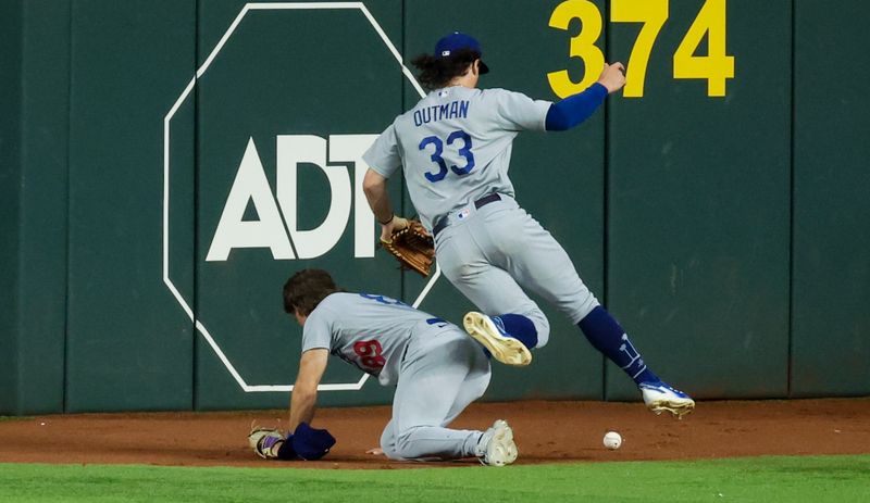 Jul 23, 2023; Arlington, Texas, USA;  Los Angeles Dodgers center fielder James Outman (33) jumps over Los Angeles Dodgers right fielder Jonny Deluca (89) to field a ball during the first inning against the Texas Rangers at Globe Life Field. Mandatory Credit: Kevin Jairaj-USA TODAY Sports