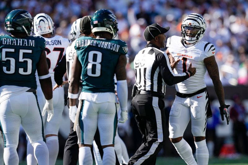 Official Anthony Flemming (90) intervenes in a conversation between Cincinnati Bengals wide receiver Ja'Marr Chase, right, and Philadelphia Eagles safety C.J. Gardner-Johnson (8) during the second half of an NFL football game, Sunday, Oct. 27, 2024 in Cincinnati. (AP Photo/Carolyn Kaster)