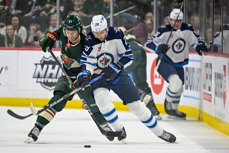 Apr 11, 2023; Saint Paul, Minnesota, USA;  Minnesota Wild forward Brandon Duhaime (21) and Winnipeg Jets forward Kevin Stenlund (28) battle for the puck during the first period at at Xcel Energy Center. Mandatory Credit: Nick Wosika-USA TODAY Sports