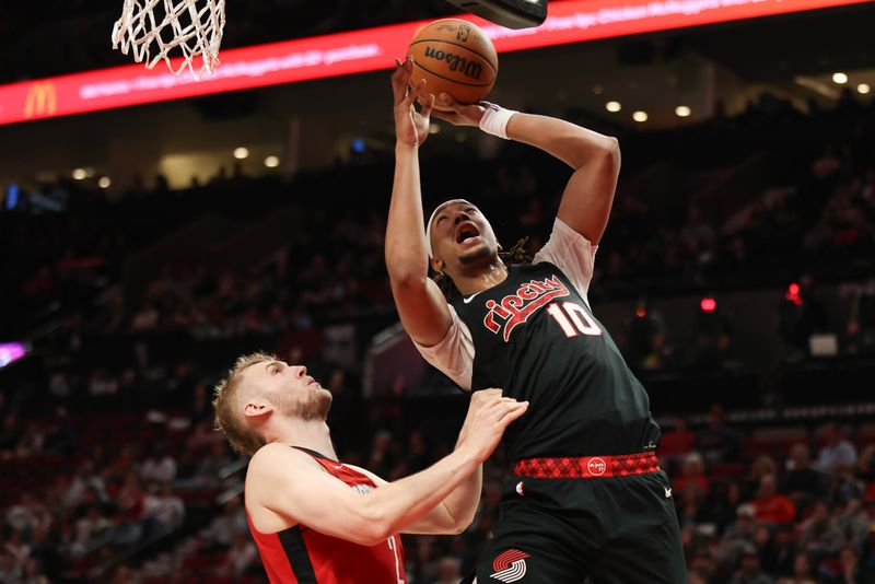 PORTLAND, OREGON - APRIL 12: Moses Brown #10 of the Portland Trail Blazers shoots off a rebound as Jock Landale #2 of the Houston Rockets defends during the fourth quarter at Moda Center on April 12, 2024 in Portland, Oregon. NOTE TO USER: User expressly acknowledges and agrees that, by downloading and or using this photograph, User is consenting to the terms and conditions of the Getty Images License Agreement.? (Photo by Amanda Loman/Getty Images)