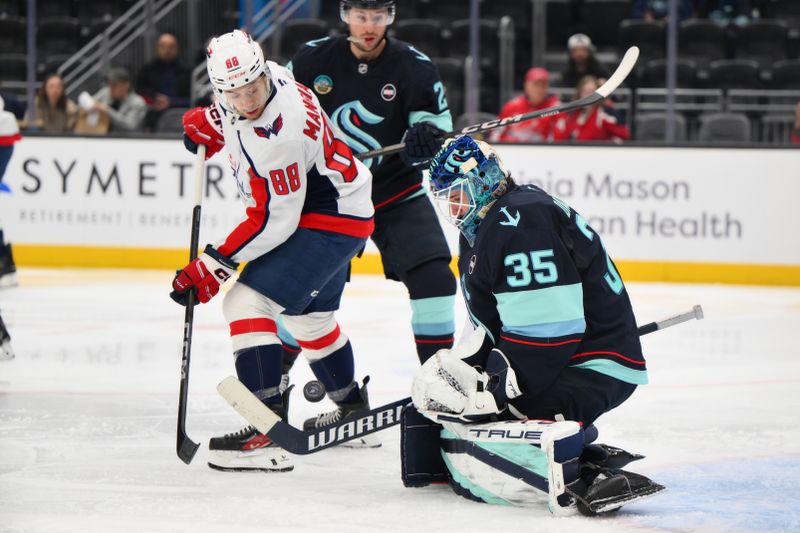 Jan 23, 2025; Seattle, Washington, USA; Seattle Kraken goaltender Joey Daccord (35) blocks a goal shot by Washington Capitals left wing Andrew Mangiapane (88) during the second period at Climate Pledge Arena. Mandatory Credit: Steven Bisig-Imagn Images