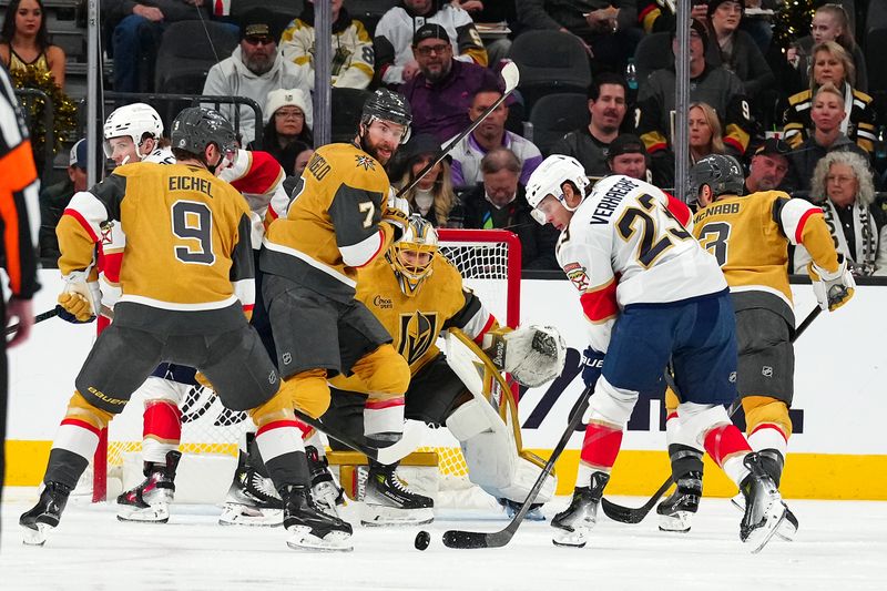 Jan 26, 2025; Las Vegas, Nevada, USA; Florida Panthers center Carter Verhaeghe (23) looks to control the puck in front of Vegas Golden Knights defenseman Alex Pietrangelo (7) and goaltender Adin Hill (33) during the second period at T-Mobile Arena. Mandatory Credit: Stephen R. Sylvanie-Imagn Images