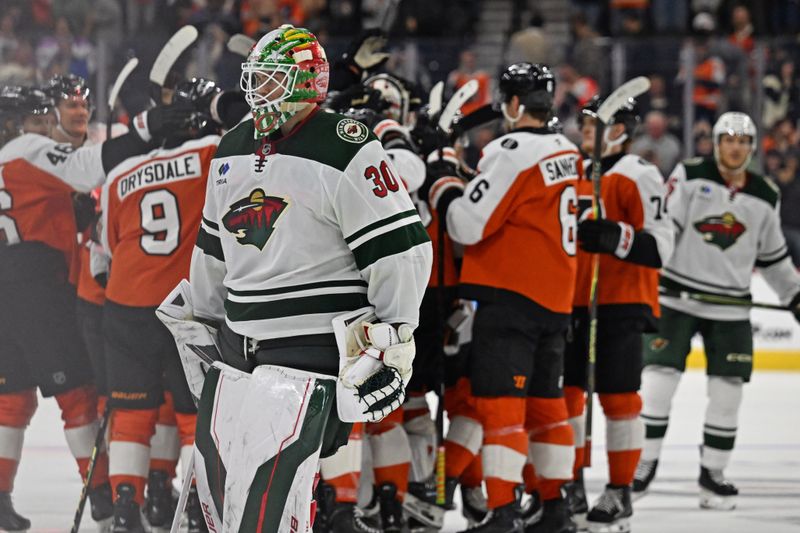 Oct 18, 2025; Philadelphia, Pennsylvania, USA; Minnesota Wild goaltender Jesper Wallstedt (30) skates off the ice as Philadelphia Flyers celebrate win during overtime at Wells Fargo Center. Mandatory Credit: Eric Hartline-Imagn Images