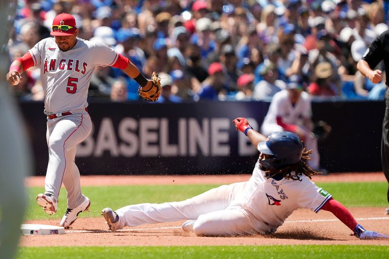Jul 30, 2023; Toronto, Ontario, CAN; Toronto Blue Jays first baseman Vladimir Guerrero Jr. (27) beats Los Angeles Angels third baseman Eduardo Escobar (5) to third base on a slide during the eighth inning at Rogers Centre. Mandatory Credit: John E. Sokolowski-USA TODAY Sports