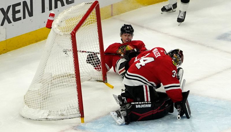 Jan 22, 2023; Chicago, Illinois, USA; Chicago Blackhawks defenseman Connor Murphy (5) dislodges the net in front of goaltender Petr Mrazek (34) during the second period at United Center. Mandatory Credit: David Banks-USA TODAY Sports