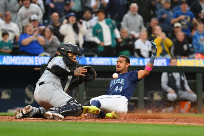 Jun 11, 2024; Seattle, Washington, USA; Seattle Mariners center fielder Julio Rodriguez (44) beats the throw to home plate to score a run against the Chicago White Sox during the seventh inning at T-Mobile Park. Mandatory Credit: Steven Bisig-USA TODAY Sports