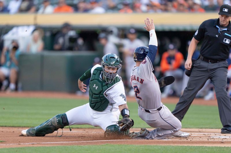 Jul 23, 2024; Oakland, California, USA;  Oakland Athletics catcher Shea Langeliers (23) tags out Houston Astros third base Alex Bregman (2) during the first inning at Oakland-Alameda County Coliseum. Mandatory Credit: Stan Szeto-USA TODAY Sports