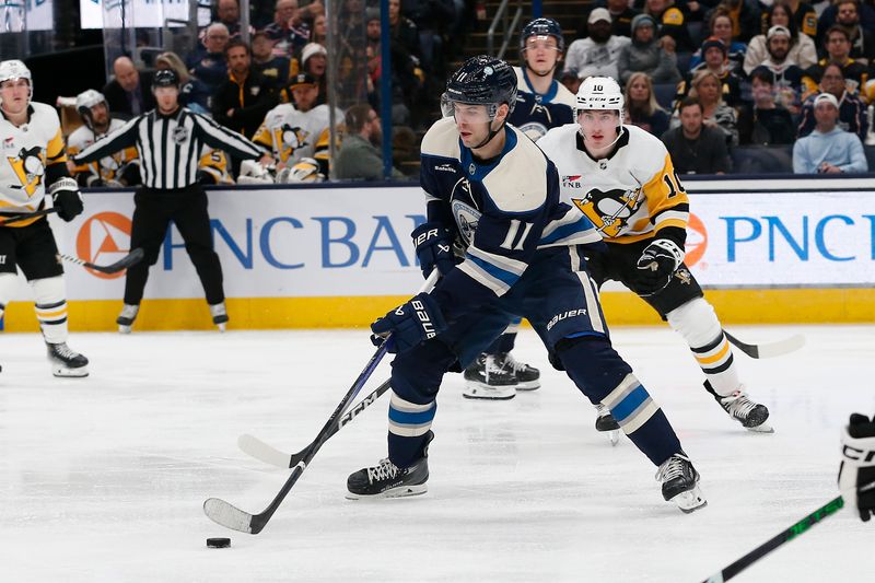 Nov 14, 2023; Columbus, Ohio, USA; Columbus Blue Jackets center Adam Fantilli (11) skates with the puck as Pittsburgh Penguins left wing Drew O'Connor (10) defends during the third period at Nationwide Arena. Mandatory Credit: Russell LaBounty-USA TODAY Sports