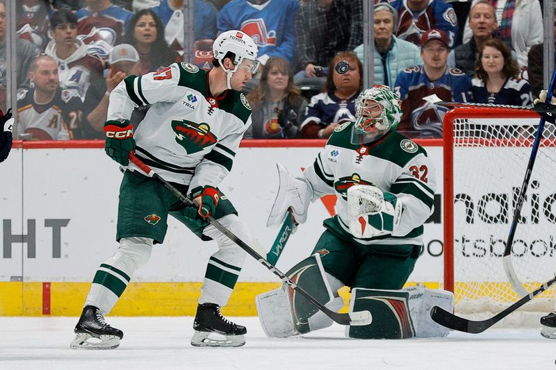 Apr 9, 2024; Denver, Colorado, USA; Minnesota Wild goaltender Filip Gustavsson (32) watches the puck after making a save as defenseman Declan Chisholm (47) defends in the first period against the Colorado Avalanche at Ball Arena. Mandatory Credit: Isaiah J. Downing-USA TODAY Sports