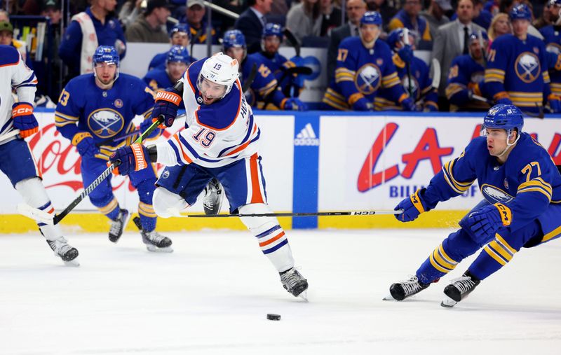 Mar 9, 2024; Buffalo, New York, USA;  Buffalo Sabres right wing JJ Peterka (77) knocks the puck off the stick of Edmonton Oilers center Adam Henrique (19) as he takes a shot during the first period at KeyBank Center. Mandatory Credit: Timothy T. Ludwig-USA TODAY Sports