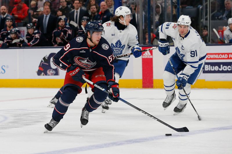 Dec 29, 2023; Columbus, Ohio, USA; Columbus Blue Jackets right wing Yegor Chinakhov (59) carries the puck as Toronto Maple Leafs center John Tavares (91) trails the play during the first period at Nationwide Arena. Mandatory Credit: Russell LaBounty-USA TODAY Sports