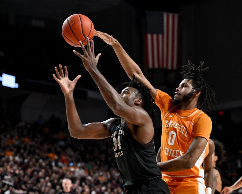 Feb 21, 2023; College Station, Texas, USA;  Tennessee Volunteers forward Jonas Aidoo (0) fouls Texas A&M Aggies forward Julius Marble (34) during the second half at Reed Arena. Mandatory Credit: Maria Lysaker-USA TODAY Sports