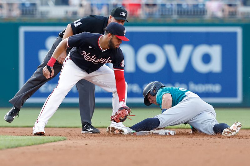 May 24, 2024; Washington, District of Columbia, USA; Seattle Mariners shortstop Dylan Moore (25) steals second base ahead of a tag by Washington Nationals second baseman Luis García Jr. (2) during the third inning at Nationals Park. Mandatory Credit: Geoff Burke-USA TODAY Sports