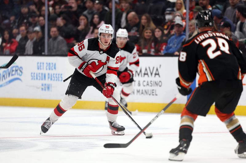 Mar 1, 2024; Anaheim, California, USA; New Jersey Devils center Jack Hughes (86) controls the puck against Anaheim Ducks defenseman Gustav Lindstrom (28) during the third period at Honda Center. Mandatory Credit: Kiyoshi Mio-USA TODAY Sports