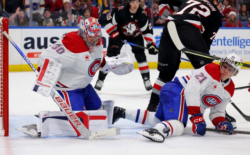 Dec 9, 2023; Buffalo, New York, USA;  Montreal Canadiens goaltender Cayden Primeau (30) watches as defenseman Kaiden Guhle (21) blocks a shot during the third period against the Buffalo Sabres at KeyBank Center. Mandatory Credit: Timothy T. Ludwig-USA TODAY Sports