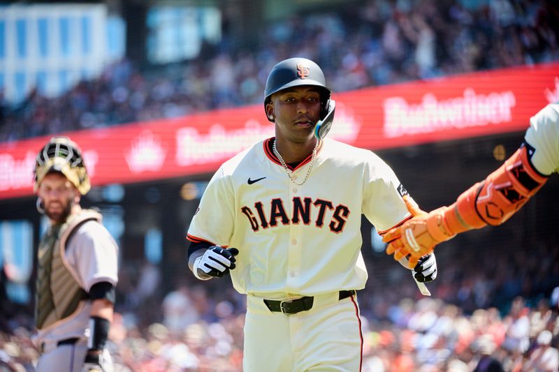 May 19, 2024; San Francisco, California, USA; San Francisco Giants infielder Marco Luciano (37) shakes hands with a teammate after scoring a run against the Colorado Rockies during the fifth inning at Oracle Park. Mandatory Credit: Robert Edwards-USA TODAY Sports