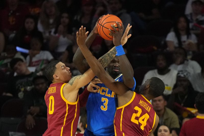 Jan 27, 2024; Los Angeles, California, USA; UCLA Bruins forward Adem Bona (3) is defended by Southern California Trojans guard Kobe Johnson (0) and forward Joshua Morgan (24) in the second half at Galen Center. Mandatory Credit: Kirby Lee-USA TODAY Sports