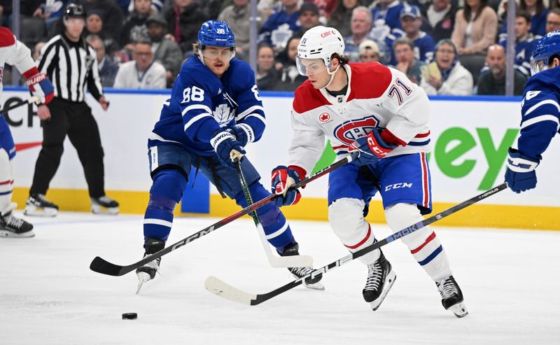 Apr 12, 2025; Toronto, Ontario, CAN;  Montreal Canadiens forward Jake Evans (71) moves the puck past Toronto Maple Leafs forward William Nylander (88) in the third period at Scotiabank Arena. Mandatory Credit: Dan Hamilton-Imagn Images