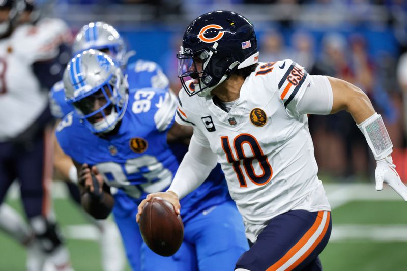 Chicago Bears quarterback Caleb Williams (18) scrambles from Detroit Lions defensive end Josh Paschal (93) during the first half of an NFL football game, Sunday, Nov. 17, 2024, in Detroit. (AP Photo/Carlos Osorio)