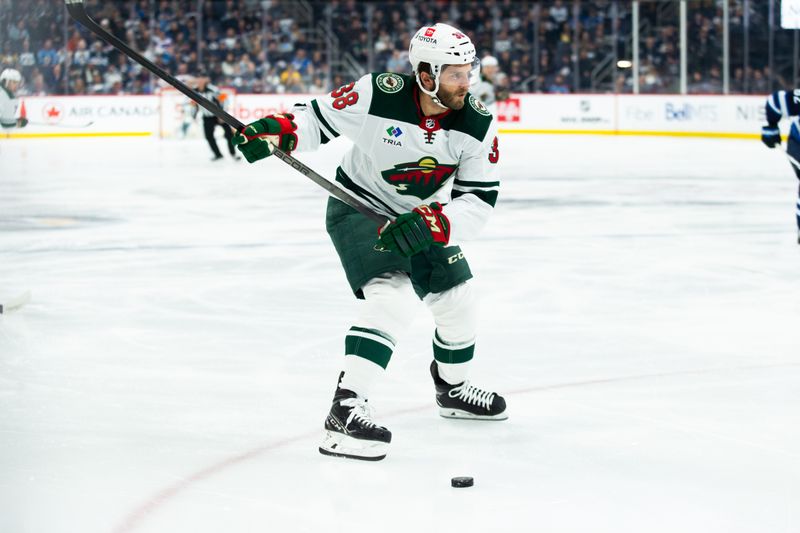 Feb 20, 2024; Winnipeg, Manitoba, CAN; Minnesota Wild forward Ryan Hartman (38) takes a shot against the Winnipeg Jets during the first period at Canada Life Centre. Mandatory Credit: Terrence Lee-USA TODAY Sports