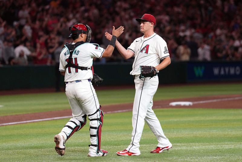 Jul 26, 2024; Phoenix, Arizona, USA; Arizona Diamondbacks catcher Gabriel Moreno (14) and Arizona Diamondbacks pitcher Paul Sewald (38) shake hands after defeating the Pittsburgh Pirates at Chase Field. Mandatory Credit: Joe Camporeale-USA TODAY Sports