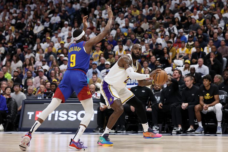 DENVER, COLORADO - APRIL 20: LeBron James #23 of the Los Angeles Lakers is guarded by Justin Holiday #9 of the Denver Nuggets in the first quarter during game one of the Western Conference First Round Playoffs at Ball Arena on April 20, 2024 in Denver, Colorado.  NOTE TO USER: User expressly acknowledges and agrees that, by downloading and or using this photograph, User is consenting to the terms and conditions of the Getty Images License Agreement. (Photo by Matthew Stockman/Getty Images)