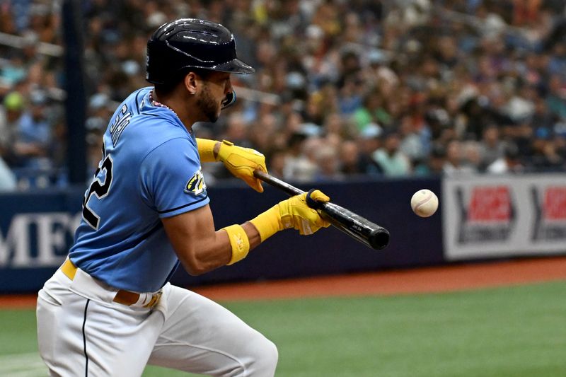 Sep 10, 2023; St. Petersburg, Florida, USA; Tampa Bay Rays center fielder Jose Siri (22) bunts for a single in the third inning against the Seattle Mariners  at Tropicana Field. Mandatory Credit: Jonathan Dyer-USA TODAY Sports