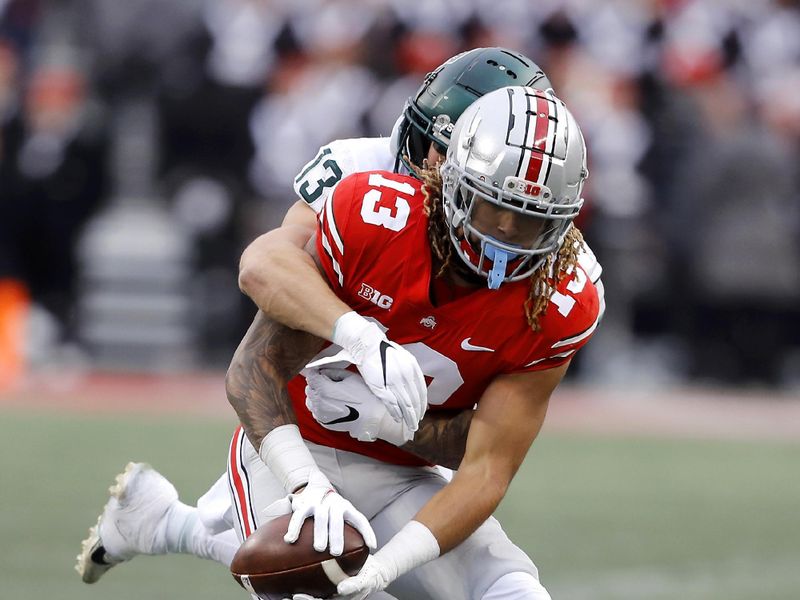 Nov 20, 2021; Columbus, Ohio, USA; Ohio State Buckeyes tight end Gee Scott Jr. (13) makes the catch while Michigan State Spartans linebacker Ben VanSumeren (13) is on his back during the second half at Ohio Stadium. Mandatory Credit: Joseph Maiorana-USA TODAY Sports