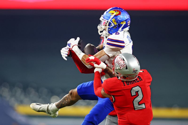 Dec 26, 2023; Phoenix, AZ, USA; Kansas Jayhawks wide receiver Quentin Skinner (0) drops a pass against UNLV Rebels defensive back Jaxen Turner (2) during the first quarter in the Guaranteed Rate Bowl at Chase Field. Mandatory Credit: Mark J. Rebilas-USA TODAY Sports