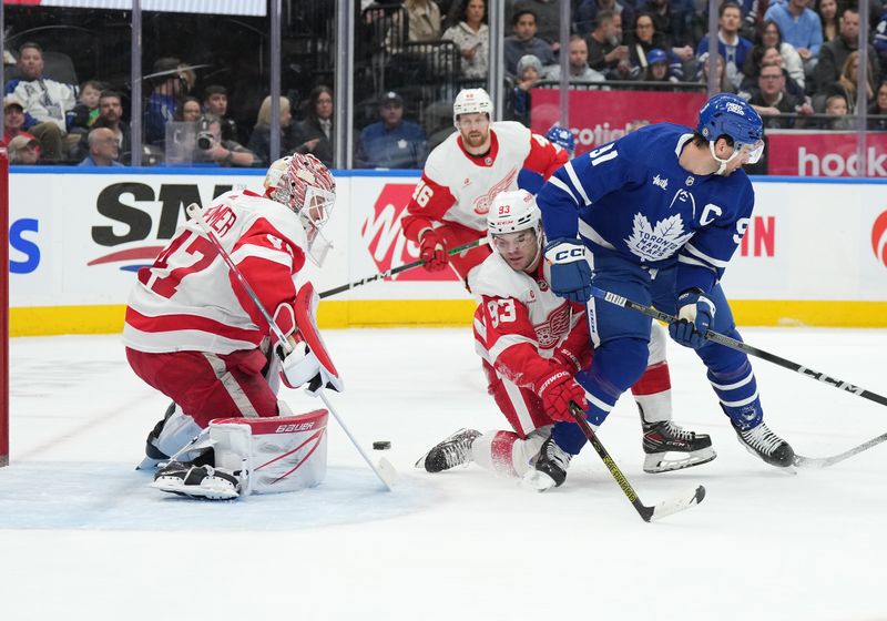 Apr 13, 2024; Toronto, Ontario, CAN; Detroit Red Wings right wing Alex DeBrincat (93) battles for the puck with Toronto Maple Leafs center John Tavares (91) during the first period at Scotiabank Arena. Mandatory Credit: Nick Turchiaro-USA TODAY Sports