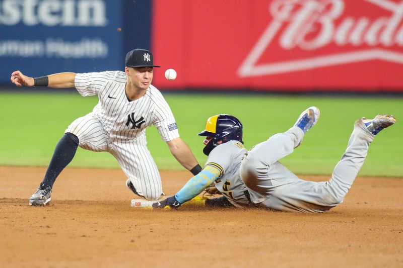 Sep 8, 2023; Bronx, New York, USA;  New York Yankees shortstop Anthony Volpe (11) is unable to hold onto the ball during a stolen base attempt by Milwaukee Brewers catcher William Contreras (24) in the seventh inning  at Yankee Stadium. Mandatory Credit: Wendell Cruz-USA TODAY Sports