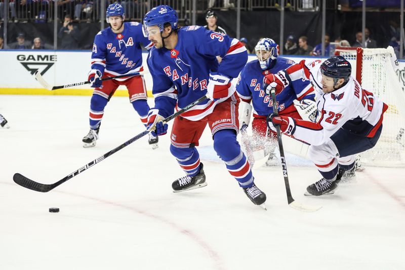 Oct 12, 2025; New York, New York, USA;  New York Rangers center Sam Carrick (39) and Washington Capitals right wing Brandon Duhaime (22) battle for control of the puck in the first period at Madison Square Garden. Mandatory Credit: Wendell Cruz-Imagn Images