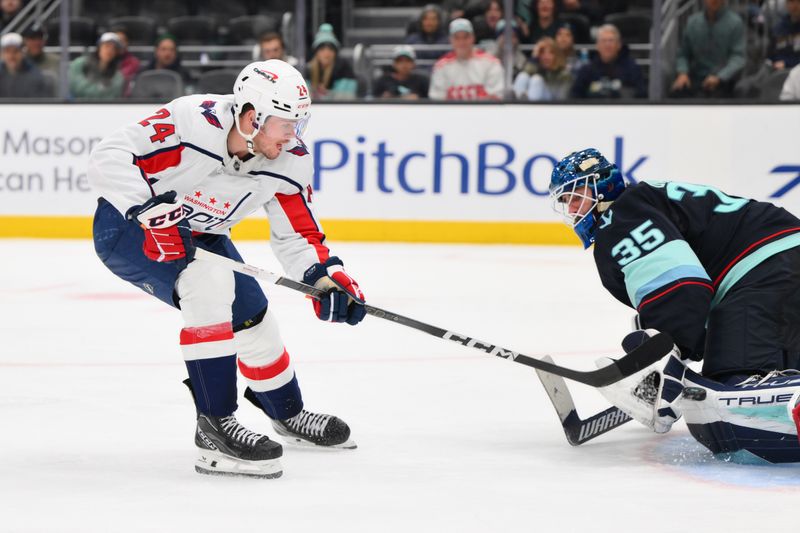 Mar 14, 2024; Seattle, Washington, USA; Washington Capitals center Connor McMichael (24) scores a goal past Seattle Kraken goaltender Joey Daccord (35) during the third period at Climate Pledge Arena. Mandatory Credit: Steven Bisig-USA TODAY Sports