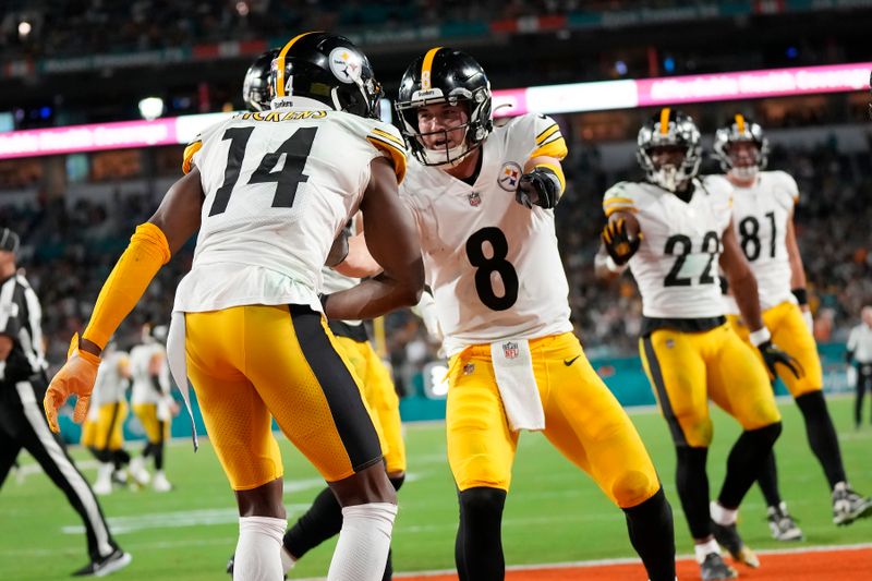 Pittsburgh Steelers quarterback Kenny Pickett (8) celebrates a touchdown by wide receiver George Pickens (14) during the first half of an NFL football game against the Miami Dolphins, Sunday, Oct. 23, 2022, in Miami Gardens, Fla. (AP Photo/Rebecca Blackwell)