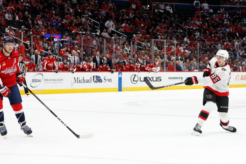 Apr 7, 2024; Washington, District of Columbia, USA; Ottawa Senators defenseman Jake Sanderson (85) scores the game-winning goal as Washington Capitals defenseman John Carlson (74) defends in overtime at Capital One Arena. Mandatory Credit: Geoff Burke-USA TODAY Sports