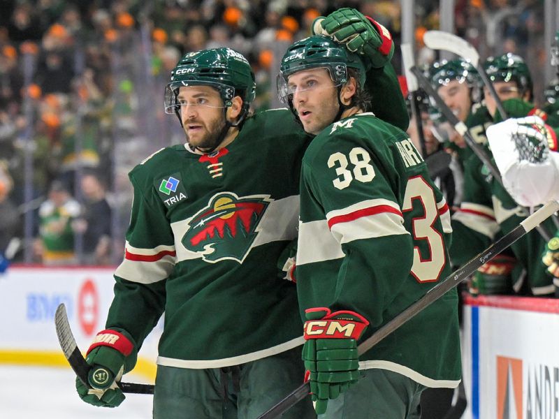 Nov 1, 2025; Saint Paul, Minnesota, USA;  Minnesota Wild forward Ryan Hartman (38) celebrates his empty-net goal against the Vancouver Canucks with forward Vinnie Hinostroza (18) during the third period at Grand Casino Arena. Mandatory Credit: Nick Wosika-Imagn Images