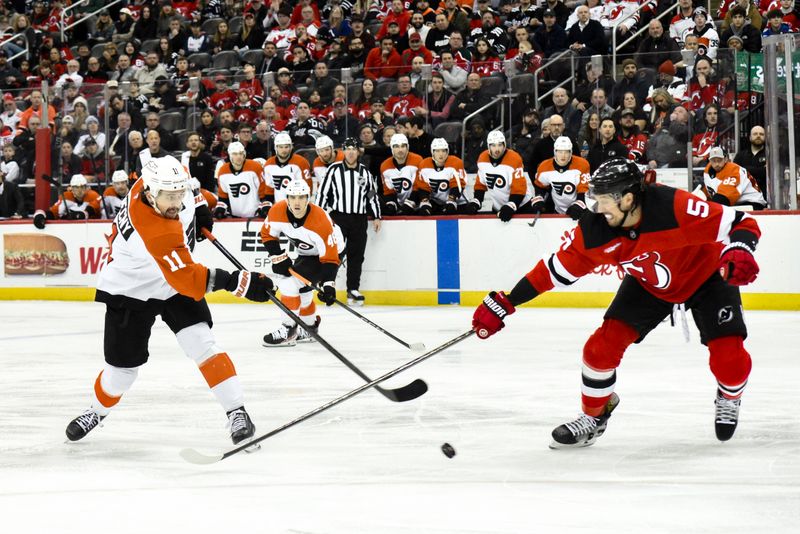 Jan 29, 2025; Newark, New Jersey, USA; Philadelphia Flyers right wing Travis Konecny (11) shoots the puck as New Jersey Devils defenseman Brenden Dillon (5) defends during the second period at Prudential Center. Mandatory Credit: John Jones-Imagn Images