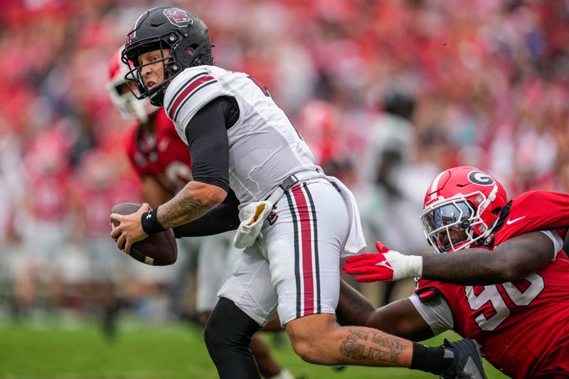 Sep 16, 2023; Athens, Georgia, USA; South Carolina Gamecocks quarterback Spencer Rattler (7) runs against Georgia Bulldogs defensive lineman Zion Logue (96) during the first half at Sanford Stadium. Mandatory Credit: Dale Zanine-USA TODAY Sports